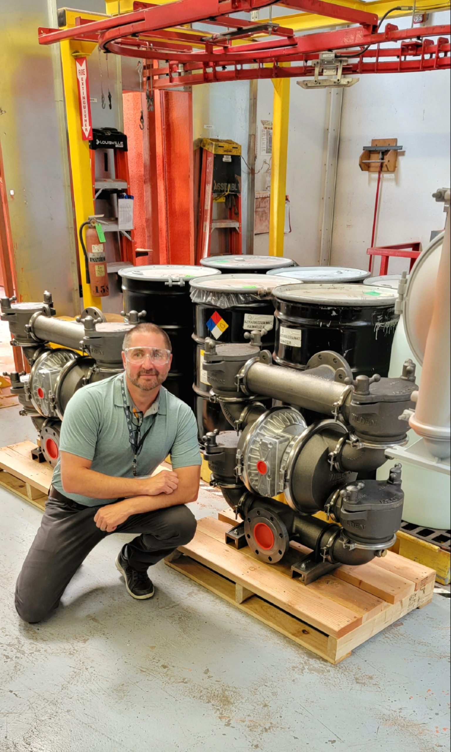 Staff member posing next to an industrial centrifugal pump
