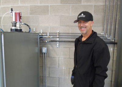 Photo of a NW Pump technician next to an industrial product