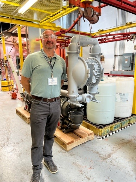 Photo of a Northwest pump representative standing near centrifugal pump loaded on a pallet