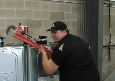 Northwest Pump technician posing with a large adjustable wrench for fun
