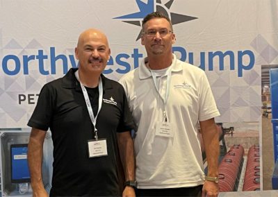 Two Northwest Pump experts posing at a trade show